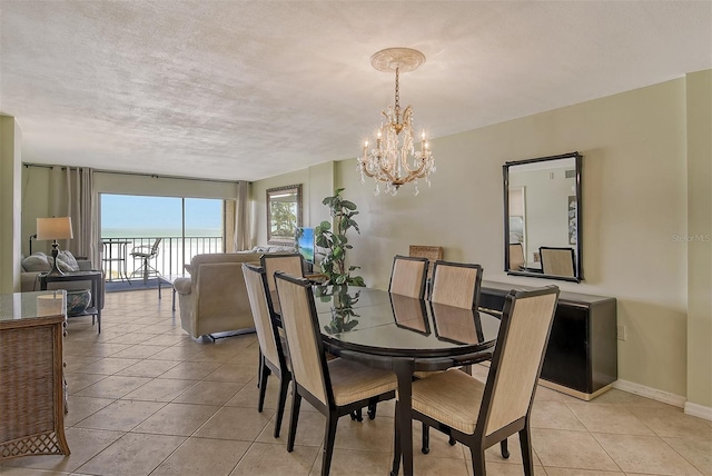 tiled dining space with a textured ceiling and a notable chandelier