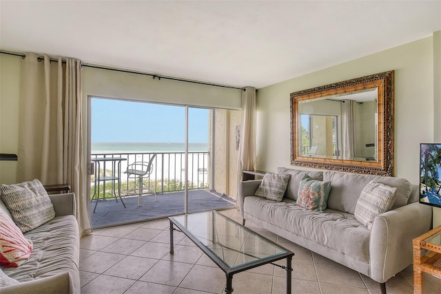 living room featuring light tile patterned flooring, a water view, and a healthy amount of sunlight