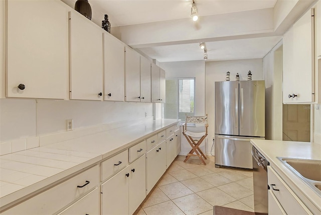 kitchen featuring light tile patterned flooring, rail lighting, stainless steel appliances, and white cabinets