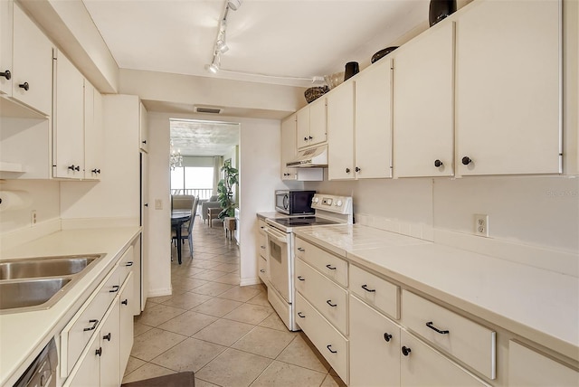 kitchen featuring white cabinetry, light tile patterned floors, stainless steel appliances, and rail lighting