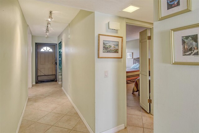 corridor with rail lighting and light tile patterned flooring