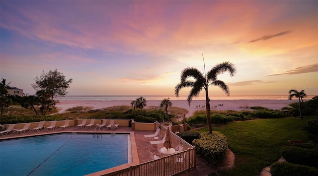 pool at dusk featuring a water view