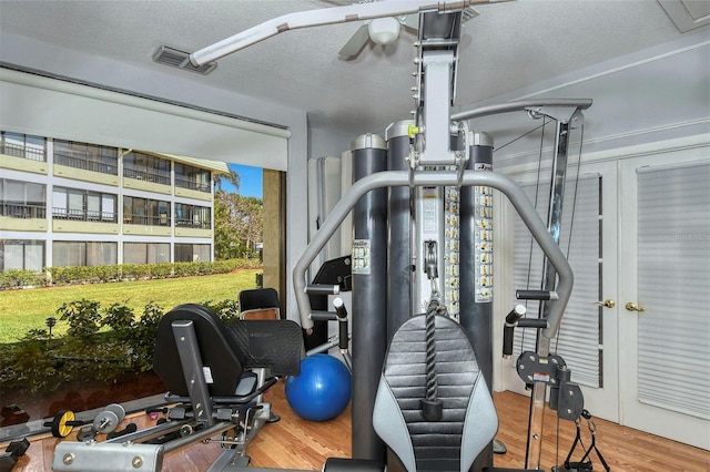 workout area featuring a textured ceiling and wood-type flooring