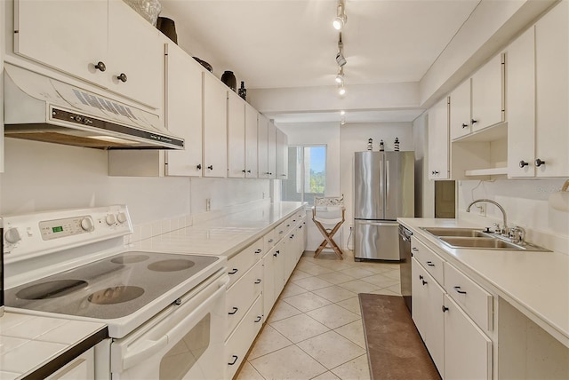19 Whispering Sands Dr Unit 204, Sarasota, FL 34242 - kitchen with stainless steel appliances, under cabinet range hood, a sink, white cabinets, and light tile patterned floors