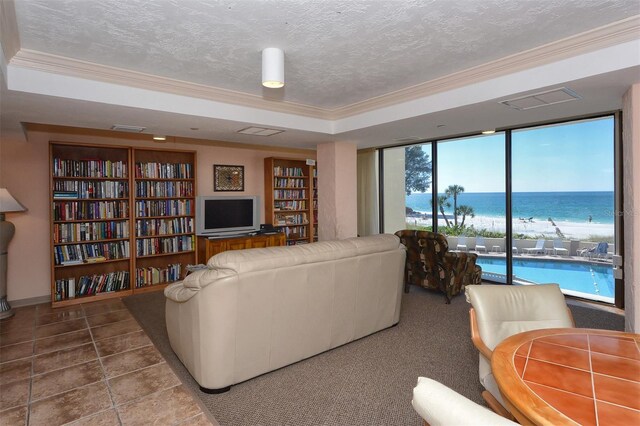 19 Whispering Sands Dr Unit 204, Sarasota, FL 34242 - living area with crown molding, a tray ceiling, and a textured ceiling