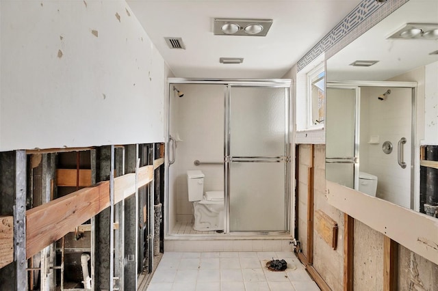 bathroom with toilet and an enclosed shower