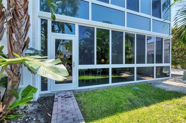 view of side of property featuring a yard and a sunroom