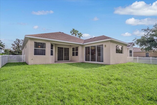 rear view of property with a lawn