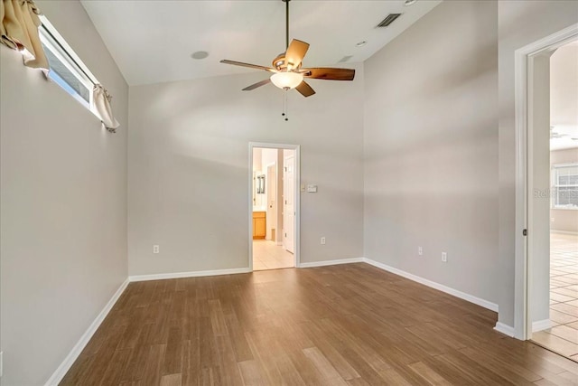 unfurnished room with ceiling fan, a healthy amount of sunlight, vaulted ceiling, and tile patterned floors