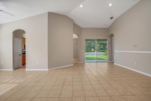 tiled empty room featuring vaulted ceiling