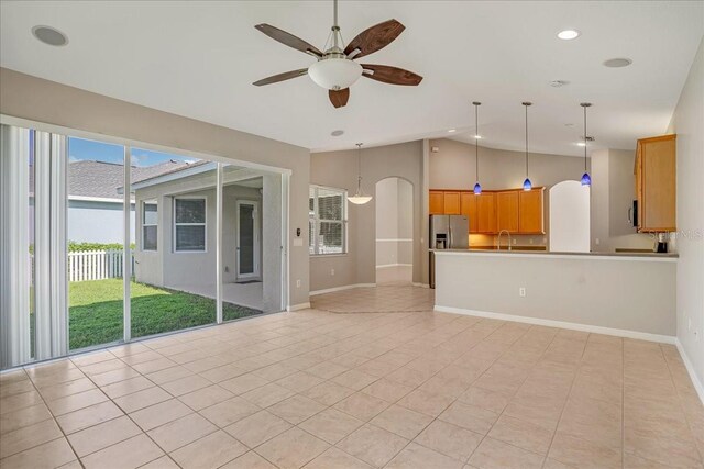 unfurnished living room featuring ceiling fan, plenty of natural light, sink, and light tile patterned flooring