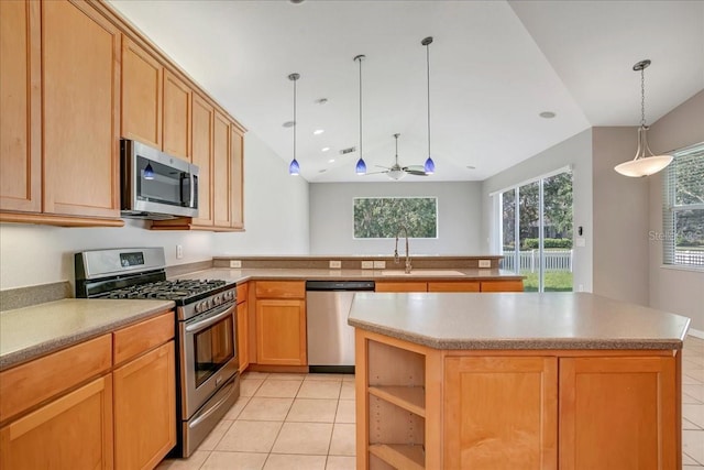 kitchen with ceiling fan, a kitchen island, appliances with stainless steel finishes, light tile patterned floors, and sink