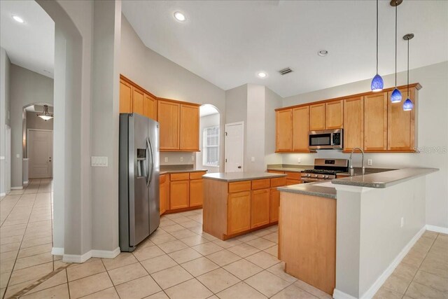 kitchen featuring hanging light fixtures, vaulted ceiling, appliances with stainless steel finishes, kitchen peninsula, and light tile patterned flooring