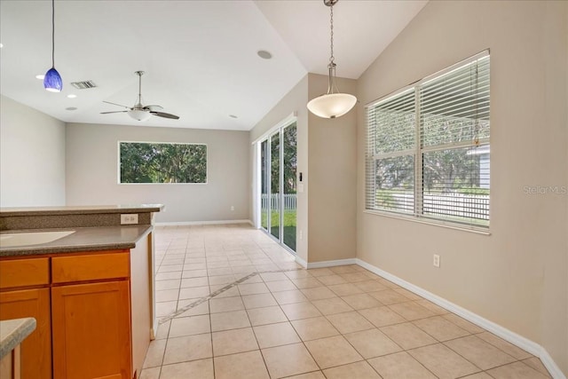 kitchen featuring sink, ceiling fan, light tile patterned floors, pendant lighting, and lofted ceiling