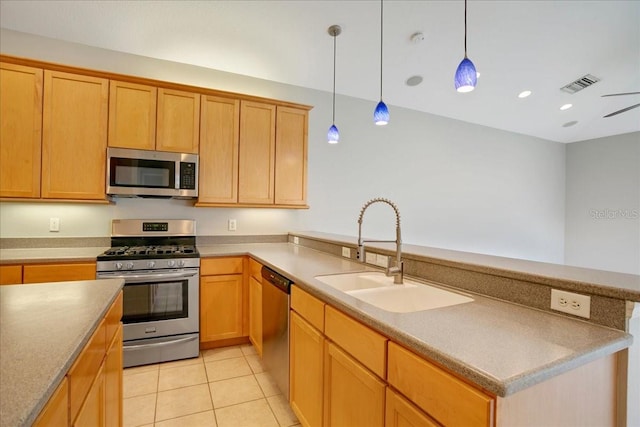 kitchen featuring sink, decorative light fixtures, appliances with stainless steel finishes, and light tile patterned floors