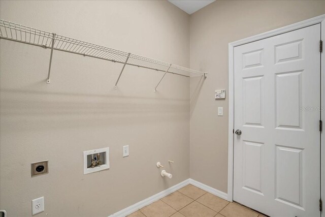 washroom with hookup for an electric dryer, gas dryer hookup, hookup for a washing machine, and light tile patterned floors