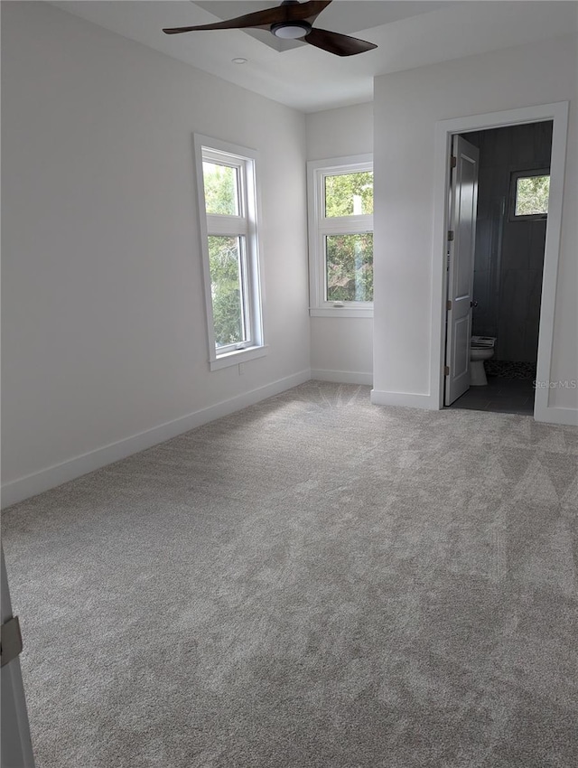 carpeted spare room featuring ceiling fan