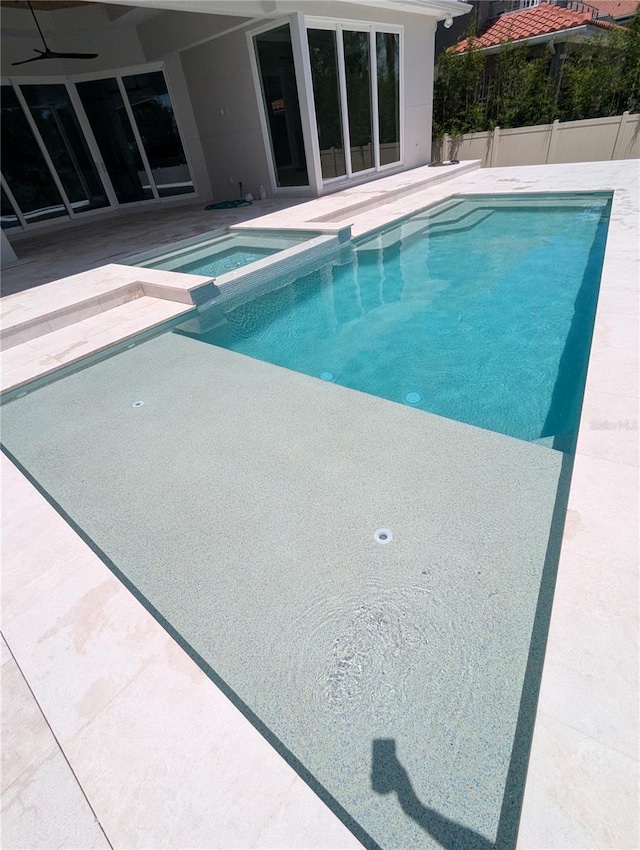 view of swimming pool featuring an in ground hot tub