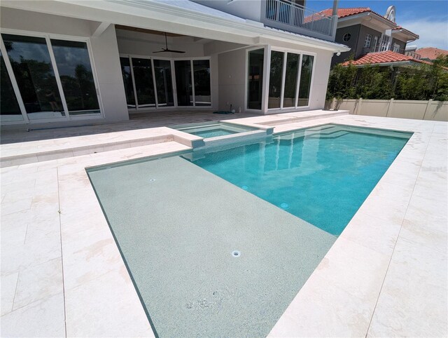 view of swimming pool featuring an in ground hot tub, a patio, and ceiling fan