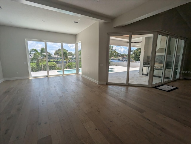 4819 Higel Rd, Sarasota, FL 34242 - unfurnished room with baseboards, wood-type flooring, healthy amount of natural light, and beamed ceiling