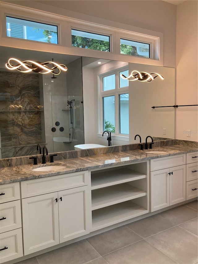 bathroom featuring tile patterned flooring, vanity, and a tile shower