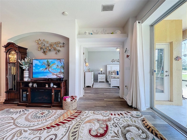 hall with hardwood / wood-style flooring and a textured ceiling