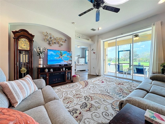 living room featuring hardwood / wood-style flooring, a textured ceiling, and ceiling fan