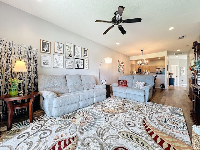 living room with ceiling fan with notable chandelier and wood-type flooring