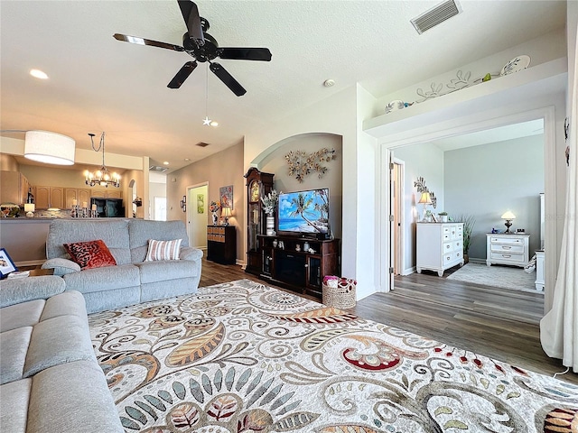 living room featuring ceiling fan with notable chandelier and wood-type flooring