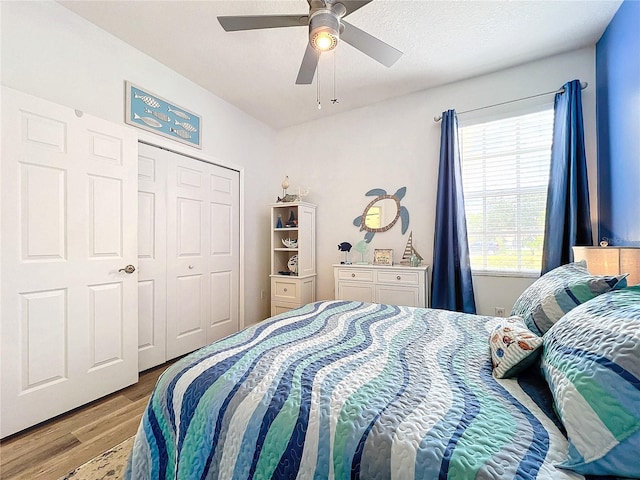 bedroom with ceiling fan, light wood-type flooring, and a closet