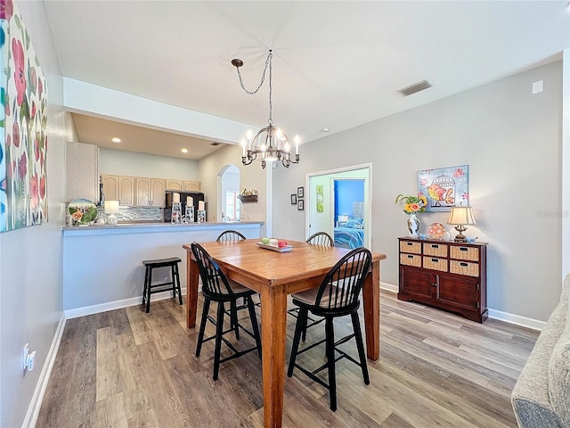 dining room with light wood-type flooring and a chandelier