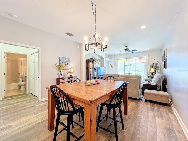 dining space with light hardwood / wood-style floors and ceiling fan with notable chandelier