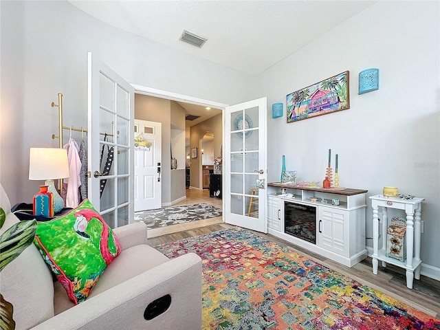 living room featuring french doors and light wood-type flooring