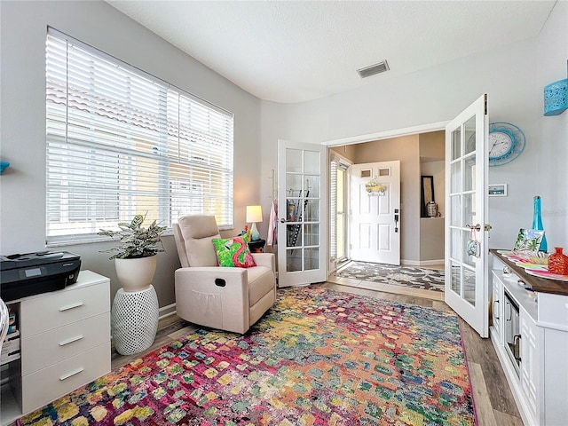 interior space with wood-type flooring and french doors