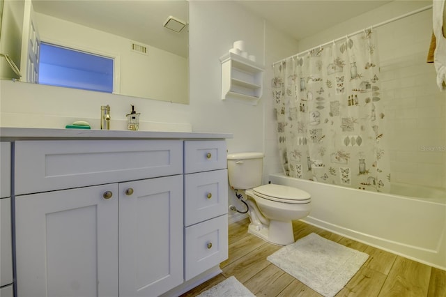 full bathroom featuring hardwood / wood-style floors, toilet, shower / bathtub combination with curtain, and vanity