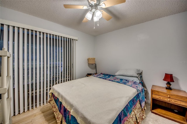 bedroom featuring ceiling fan, a textured ceiling, and light hardwood / wood-style floors