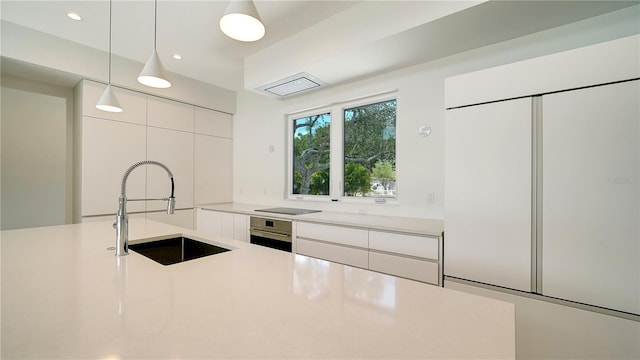 2231 Wood St, Sarasota, FL 34237 - kitchen with modern cabinets, oven, light countertops, a sink, and built in fridge