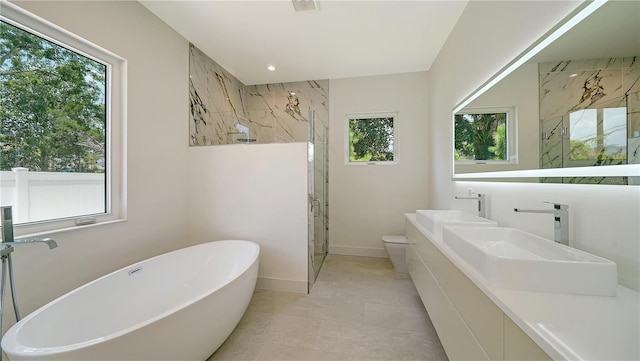 bathroom with toilet, double vanity, and tile patterned flooring