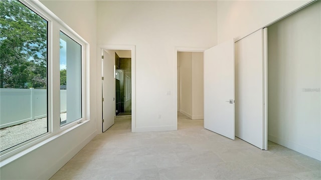 unfurnished bedroom with light tile patterned floors and a high ceiling