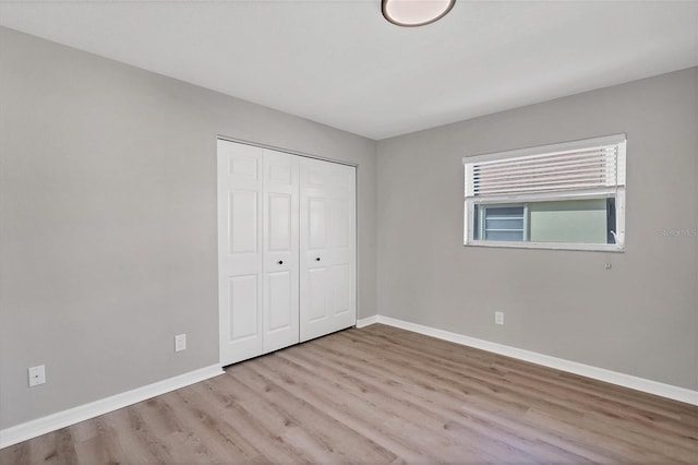 unfurnished bedroom with wood-type flooring and a closet