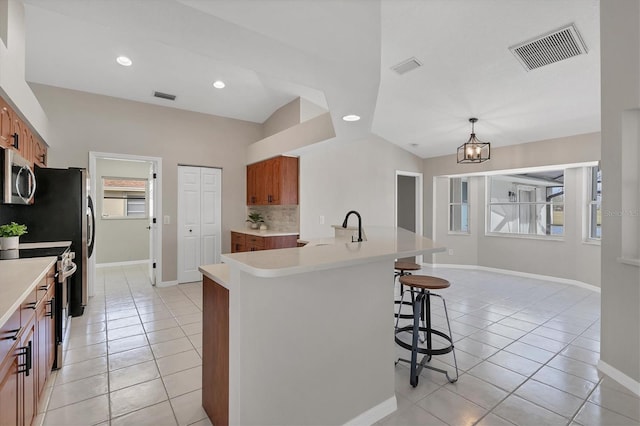 kitchen featuring pendant lighting, stainless steel appliances, plenty of natural light, and light tile patterned floors