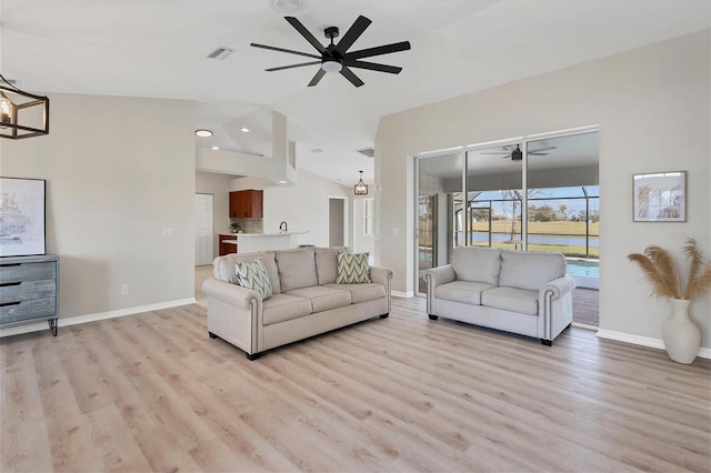 living room with ceiling fan with notable chandelier, light wood-type flooring, and lofted ceiling