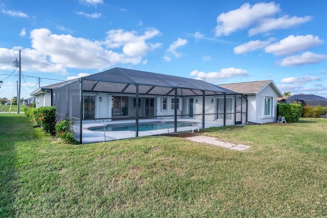 back of house with a lanai, a patio area, and a lawn