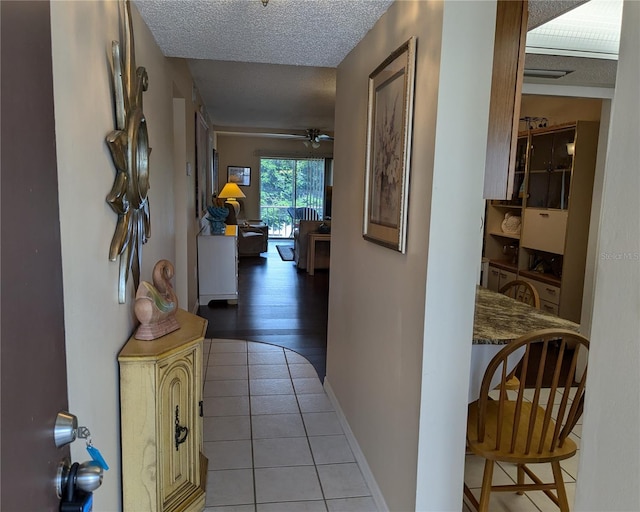 hallway with a textured ceiling and hardwood / wood-style flooring