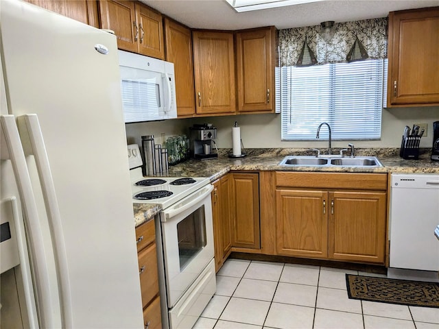 kitchen featuring light tile patterned flooring, sink, and white appliances