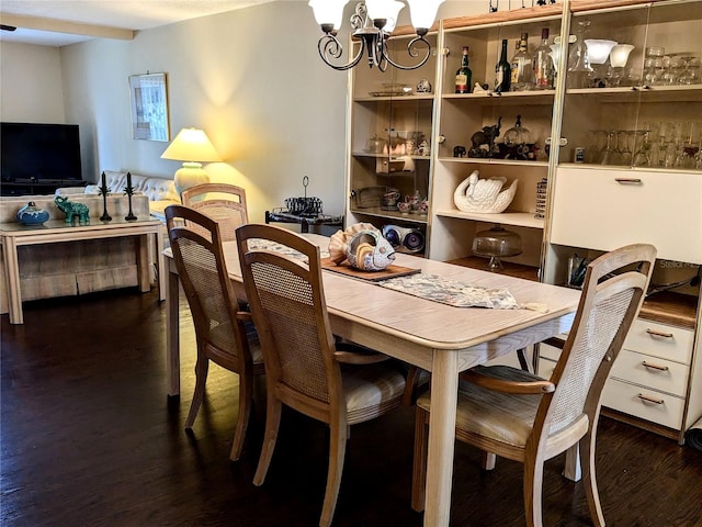 dining space featuring dark wood-type flooring and a chandelier