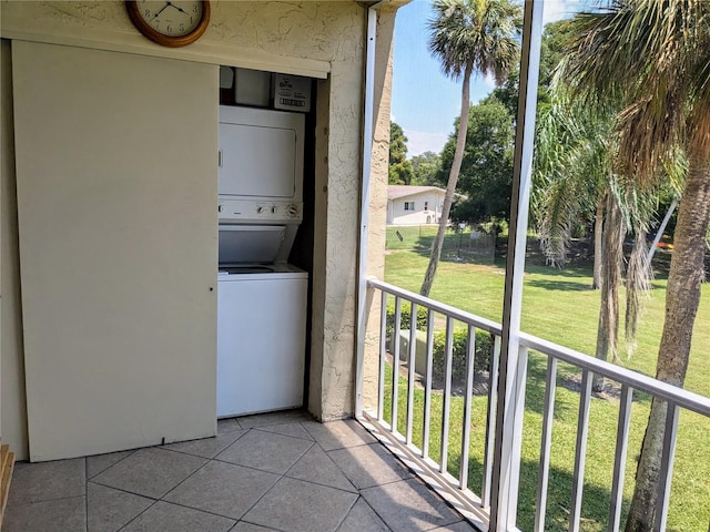 laundry area featuring light tile patterned flooring and stacked washer / dryer