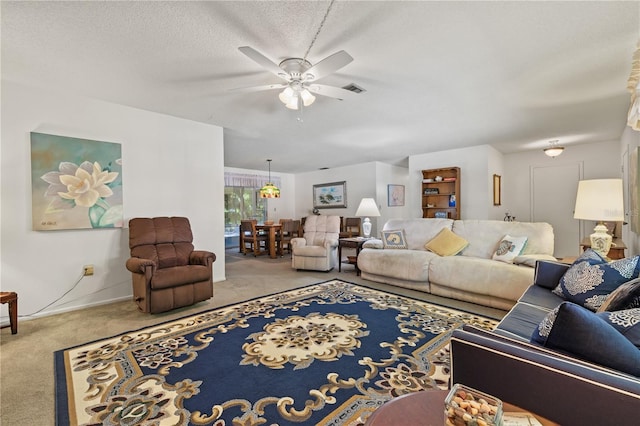 carpeted living room with visible vents, ceiling fan, and a textured ceiling