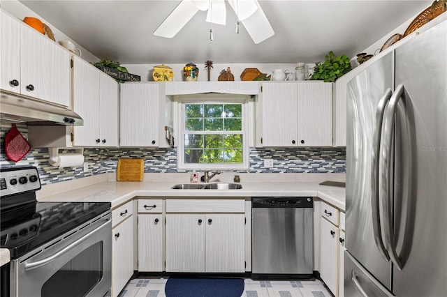 kitchen with under cabinet range hood, a sink, light countertops, appliances with stainless steel finishes, and backsplash