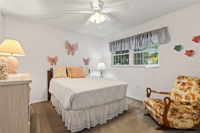 bedroom with dark carpet, ceiling fan, and a textured ceiling